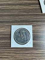 Front side of 1958 Canadian silver dollar coin showing totem pole design and inscriptions.