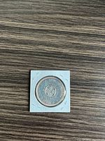 Reverse side of the 1964 Canadian silver dollar coin featuring the floral emblem and inscriptions.