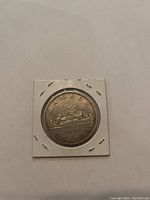 Reverse side of the coin featuring a voyageur with an Indigenous person paddling a canoe, with inscriptions 'Canada Dollar' and the date 1966.