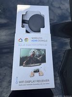 Front of package showing the wireless HDMI dongle inside its holder and branding indicating compatibility with Google Chrome and Home app, with a visual of content casting from phone to TV.