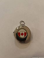 Closed view of the compass showing the Canadian flag emblem on the lid with the word 'CANADA'.