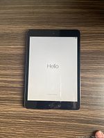 Front view of Apple iPad Mini powered on showing 'Hello' welcome screen