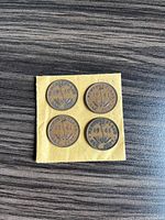 Reverse side showing 'NEWFOUNDLAND ONE CENT' and year on four pennies from 1941 and 1942 mounted on a yellow card.