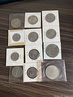 22 vintage silver coins from USA in protective holders on table