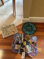 Overview photo of barware and accessories on floor with serving trays and glassware.