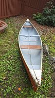 Frontiersman fiberglass canoe upright interior showing two wooden bench seats and center tow rope