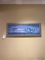 Full view of the framed elephant print hung on a wall showing the entire artwork and frame.
