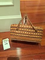 Front view of basket showing checkered pattern and dual wrapped handle