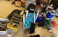 Full overview of outdoor equipment including fishing tackle boxes, coiled ropes, lawn chairs, backpack, and miscellaneous items.