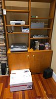 Wide view of the wooden shelf unit holding ION turntable, Panasonic stereo system with CD player and speakers, and several music CD cases.