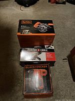 Boxes of the three power tools: Black & Decker circular saw, Porter Cable grinder, and Black & Decker drill.