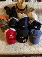 All hats and caps displayed on mattress showing assortment including brands and types