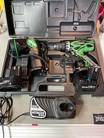 Shot of the drill, flashlight, two 12V batteries, charger, and carrying case interior.