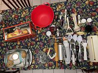 Overview of all kitchen items arranged on a table with floral cloth
