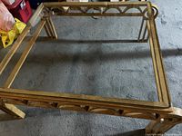 Top view of the coffee table showing the glass top and metal decorative frame.