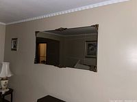 Full view of the large rectangular wall mirror mounted on a beige wall, showing size and placement.