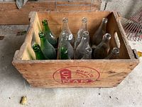 Wooden crate labeled CYNAR DRY Ltd Toronto Canada with nine mixed green and clear glass bottles inside.