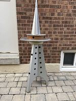 Assembled sculpture standing at full height against brick wall