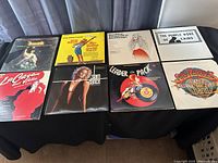 Photo showing 8 LP record covers including Joseph, The Man of La Mancha, The Purple Rose of Cairo, La Cage aux Folles, Leader of the Pack, Sweeney Todd, and Fiddler on the Roof, all arranged on a black surface.