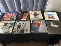 Various LP record covers visible on table showing soundtracks from movies and stage productions including The Godfather, Summer Lovers, and others.