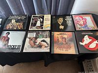 Full spread of 8 LP record covers featuring movie soundtracks Rocky III, Hamlet, Mad Max, Ghostbusters, Against All Odds and others.