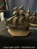 Close-up of cast iron ship bookend showing detailed sails and hull, dark patina finish.