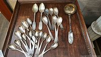 Overview of all spoons and ladle arranged on wood surface