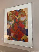 Front view of the abstract print in a silver frame with white mat showing multicolored overlapping shapes.