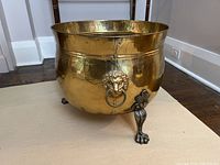 Front corner view showing lion head ring handle and claw foot