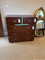 Front view of two-piece dresser assembled with brass corner protectors and recessed handles