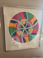 Close-up straight-on view of framed abstract circular print; shows color and detail