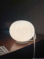 Lamp illuminated on wooden surface against dark background