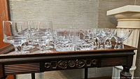 Three groups of glasses on wooden tray: 6 swirl-pattern cocktail glasses, 6 ribbed Gaissa glasses, 6 small liqueur glasses with bubble stems