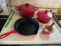 Overhead view showing all Le Creuset cast iron pieces and ceramic mortar and pestle