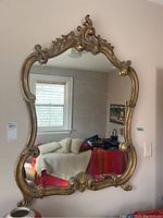 Full front view of the mirror mounted on wall reflecting room interior.