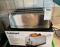 Stainless steel Cuisinart toaster with original box visible beneath on kitchen counter.