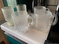 All five pieces displayed together: three mugs in front, two tumblers behind