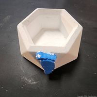 Top-down view showing the hexagonal shape and blue handle on the white handmade box.