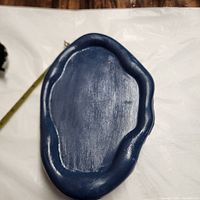 Blue handmade jesmonite tray laid flat on white surface, showing organic, irregular wavy shape and smooth finish.