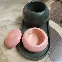 Top view of the pink and black decorative boxes on the green tray