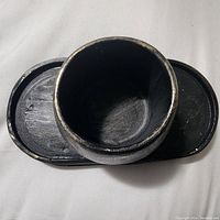 Top-down photo of the black jesmonite oval tray with cylindrical box showing smooth black finish with subtle silver highlights.