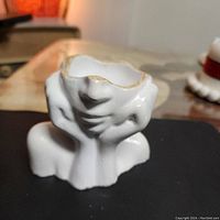 View of handmade decorative box shaped as an abstract face, showing front and base details.