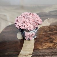 Close-up angled photo showing the detailed pink rose cluster with silver base and pink bow accent.