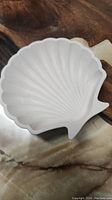 Close-up of white seashell shaped handmade tray showing ridged shell pattern and jesmonite material texture.