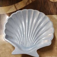 Front view of the light blue seashell-shaped tray showing scallop shell design and ridges, made from jesmonite.
