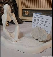 Photo showing white jesmonite tray with thinker statue in seated contemplative pose and cloud-shaped card holder holding a card.