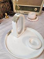 Overall view showing handmade white jesmonite tray, arch-shaped vase with glass test tube, and round candle holder with gold glitter accents.