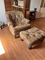 Arm chair and ottoman with paisley fabric upholstery, button tufting, and wood bun feet