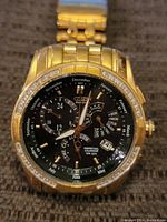 Front view of watch face showing black dial, subdials, date window, bezel crystals