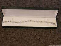 Full view of the bracelet inside a jewelry box, showing the entire length and clasp.